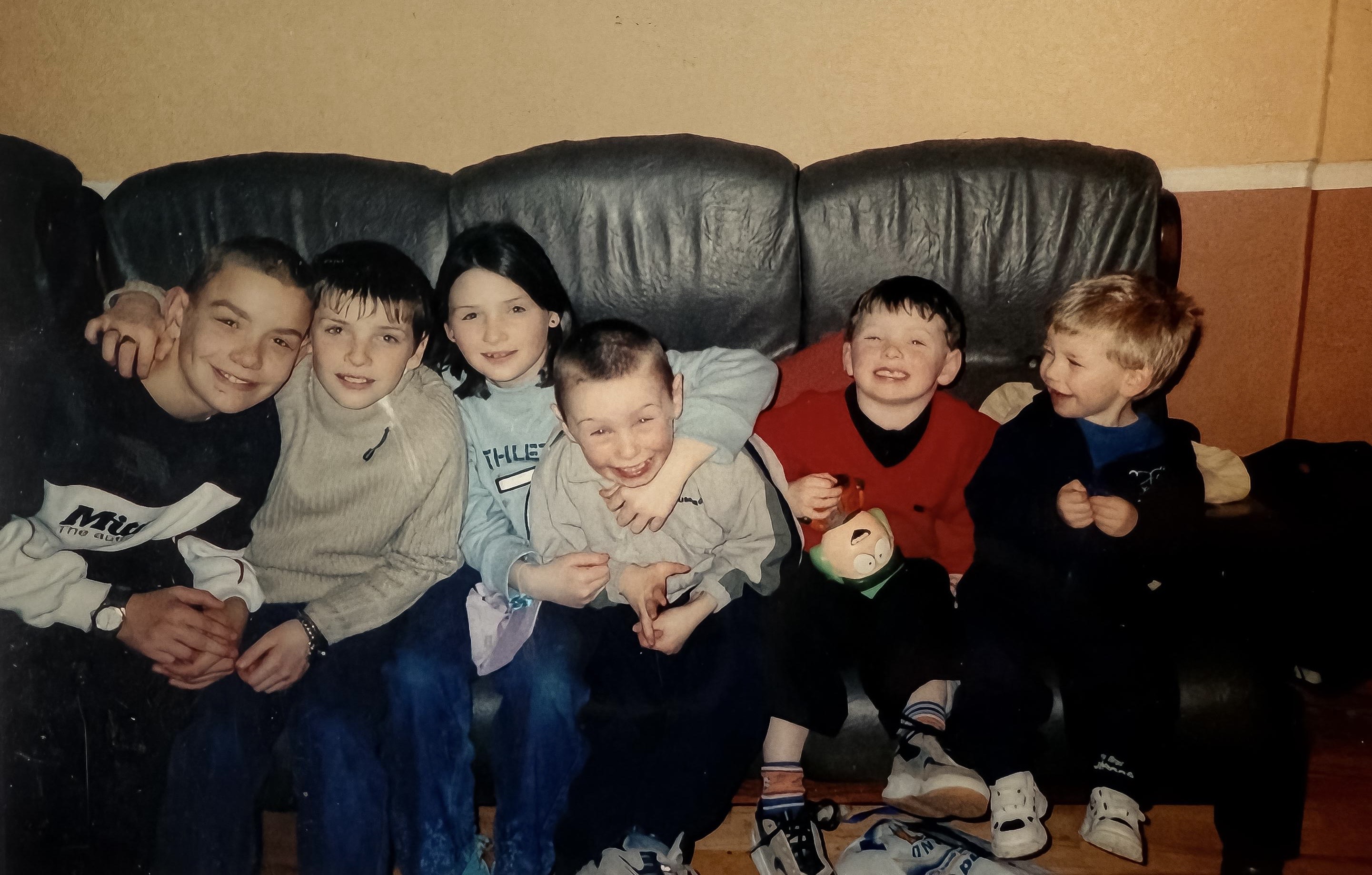 Six children sitting on a couch in inner-city Dublin
